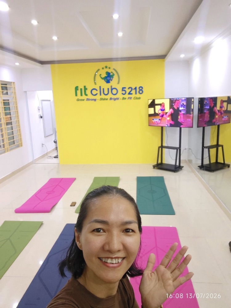 Chị Phan Diệu trong phòng tập Fit Club 5218 với bức tường vàng và các thảm tập đủ màu